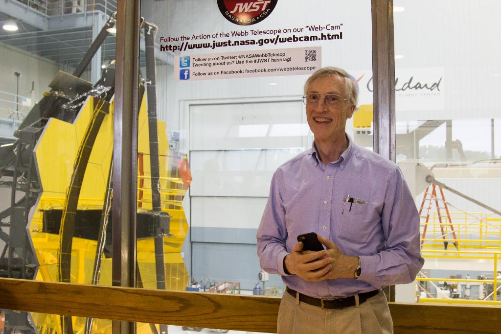 John Mather, Senior Project Scientist for JWST, with the James Webb Space Telescope primary mirror at NASA's Goddard Space Flight Center in Greenbelt.