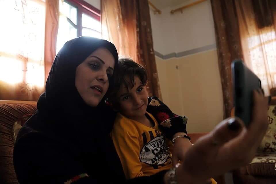 palinheart's tweet photo. The Palestinian mom, Nevin Abu Gharqoud, from Gaza is talking with her kids, who live in Qalqilya city via the phone, since the israeli occupation refused to grant her a permit to live with them. https://t.co/GOhnwOjc4J