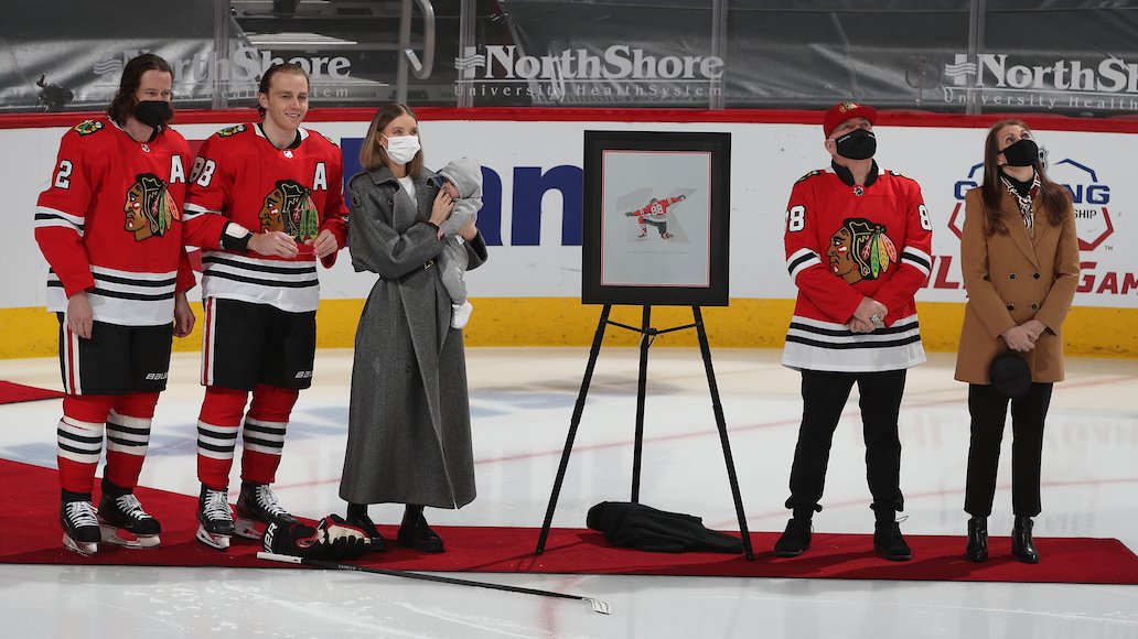 NHLBlackhawks's tweet photo. Per Patrick Kane’s wish, we won’t 𝘧𝘶𝘭𝘭𝘺 celebrate until we can share the moment with a packed house of #Blackhawks fans.

But since it's our first home game since his 1,000th NHL game on March 9, we recognized Kaner's achievement with his family.

#1Kane https://t.co/BJ4hx022uM