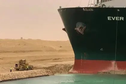 Si algún día te sientes inútil, piensa en la escavadora que está desatascando el carguero que bloquea el canal de Suez.