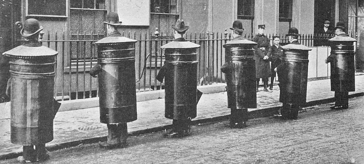 CabMirror's tweet photo. Men dressed as postboxes on Frith Street, Soho in November 1903. This was an advertising gimmick to promote a postcard exhibition which was being held on Grafton Street in Mayfair. https://t.co/mEehDe07OT