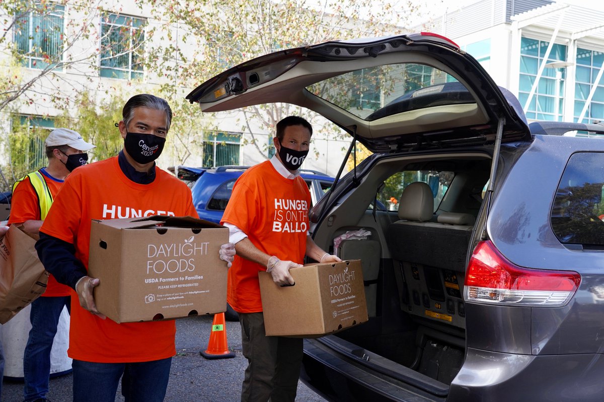 Photo of Attorney General nominee Rob Bonta and Chief Service Office Josh Fryday helping unload food boxes at a local food bank.