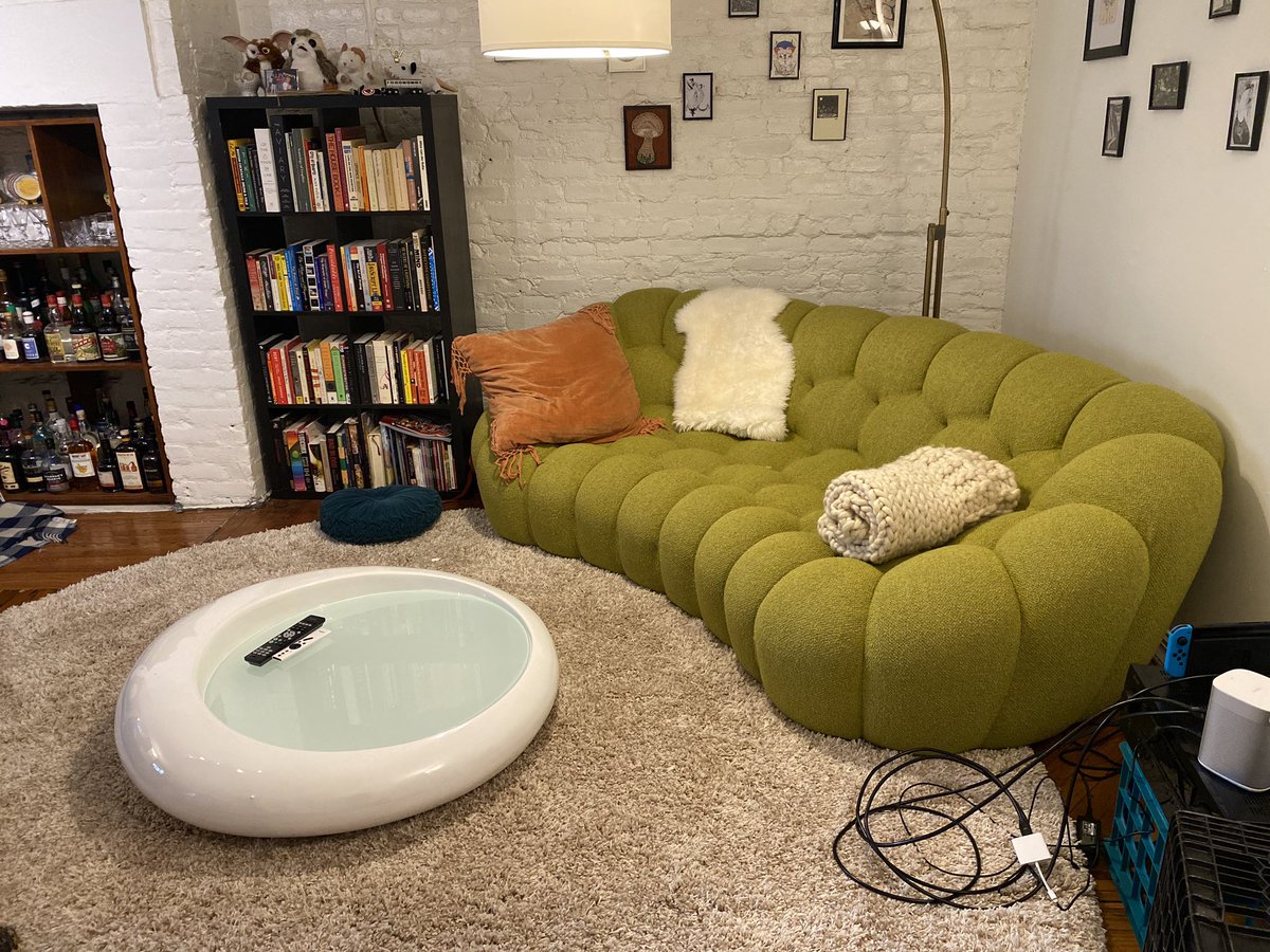 a white fiberglass coffee table with a roundish abstract shape & a circular glass surface