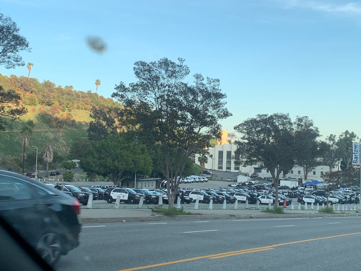 PplsCityCouncil's tweet photo. LAPD staging near Echo Park Lake. Under the direction of the city of Los Angeles and @MitchOFarrell, the cops are going to raid the Echo Park Lake encampment and evict hundreds of residents of the park. 

We can see what the city is doing. ALL EYES ON ECHO PARK TONIGHT https://t.co/YgZKNRhshW