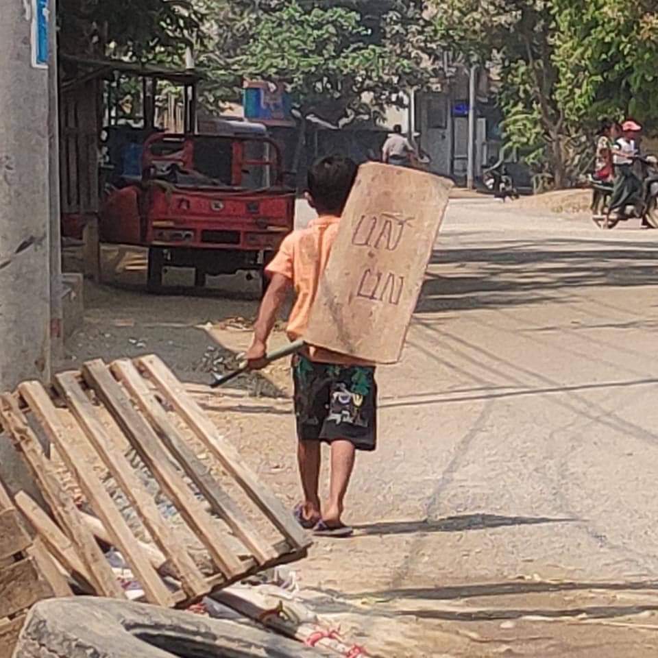 SaveMyanmar01's tweet photo. This little kid was preparing barricades in order to prevent Junta from destroying them.

He only has a thin piece of wooden shield that says “ UN “

We all are waiting for international help yet they are hesitating 

We only have each other to protect #WhatsHappeningInMyanmar https://t.co/nS4Yf5nLPy