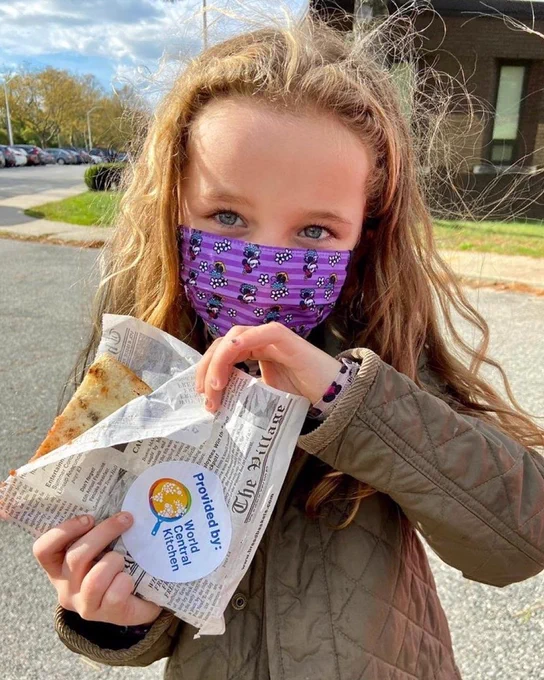A young girls holds a sandwich.