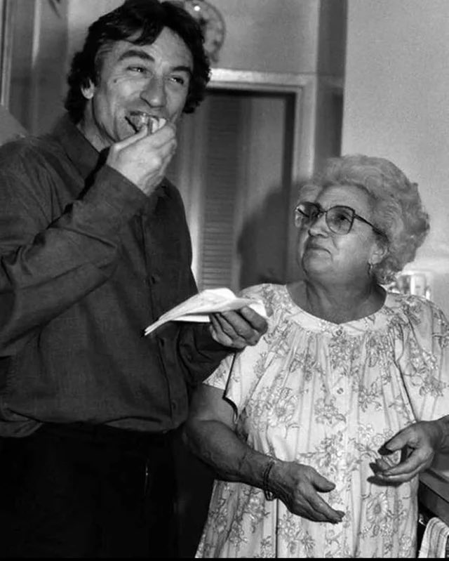Robert De Niro eats a slice of pizza made by Martin Scorsese’s mother, Catherine, on the set of GOODFELLAS in 1989.
