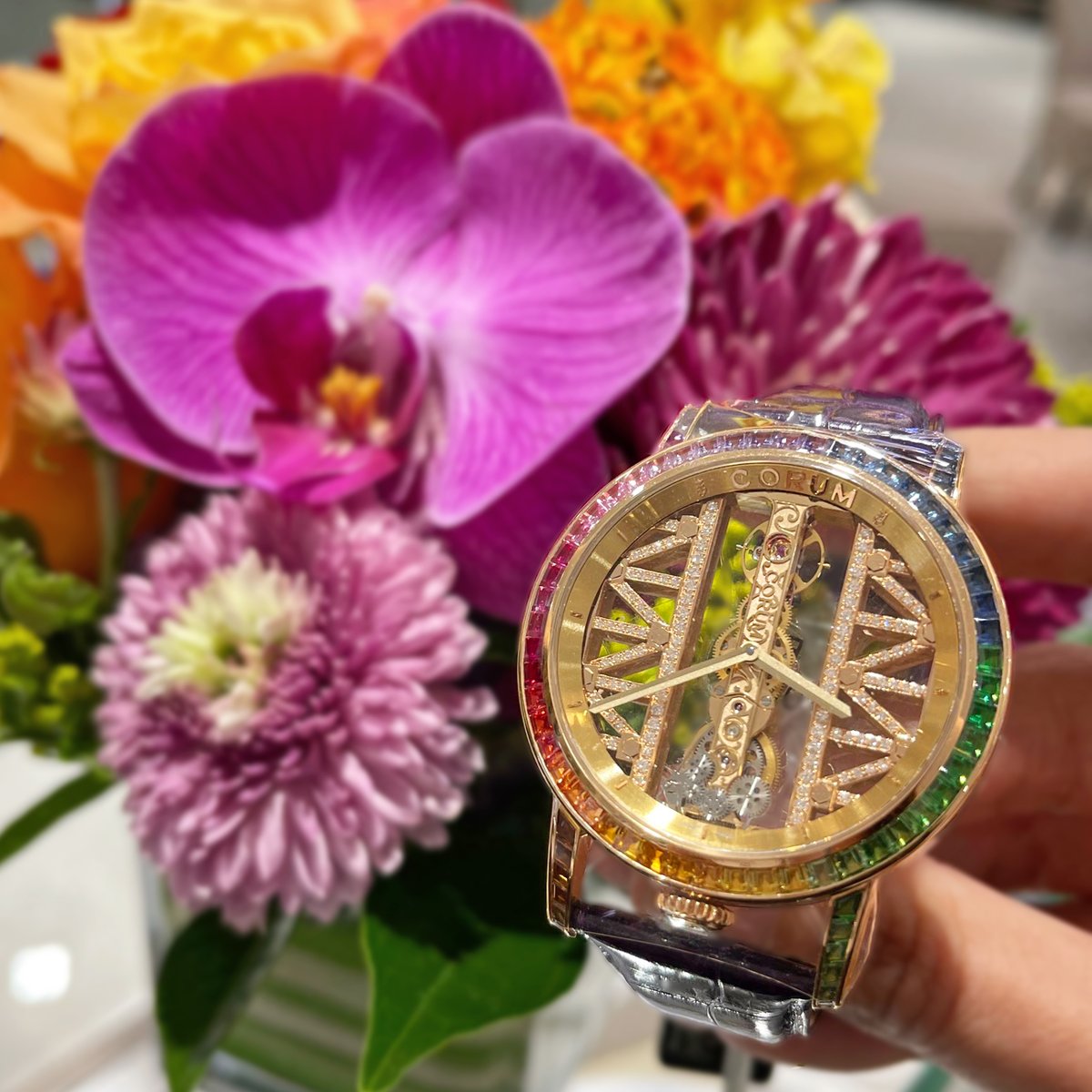 Over the rainbow 🌈  The gorgeous rainbow Corum Golden Bridge features multi-color sapphires, peridots, tsavorites, and rubies set in 18k yellow gold. See this spectacular timepiece in person at #ProvidentJewelry.
