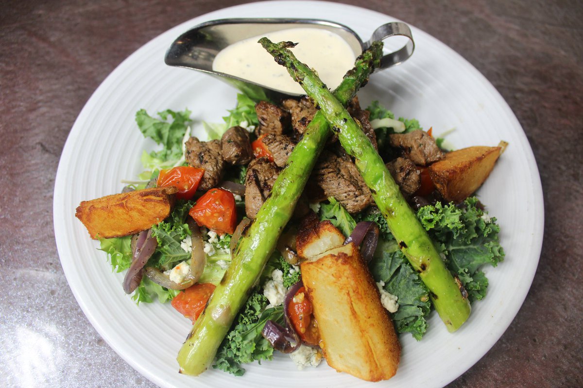 Our colorful Tenderloin Steak Salad is created with char-broiled filet tips, fried potato wedges, roasted tomatoes, grilled onions, and blue cheese crumbles atop a mixed greens and kale blend; served with our house dressing! 🥗🥩