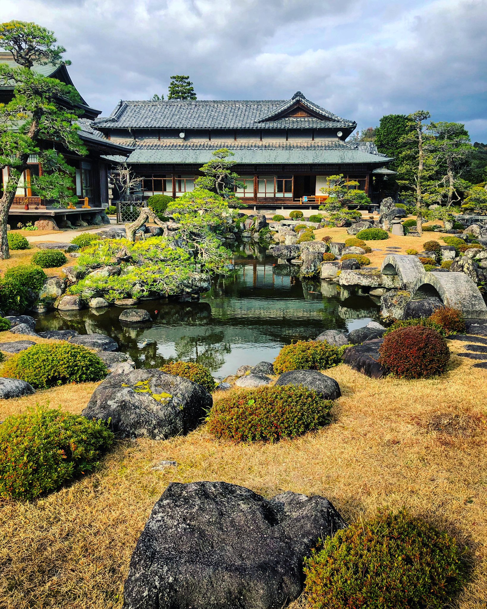 日本庭園メディア おにわさん The Japanese Gardens 旧藏内氏庭園 一面田んぼの 田舎 の風景の中にたたずむ豪邸 まず県道からの参道の長さと石橋 石鳥居がすごい 大玄関 まず入母屋造二重屋根の玄関がデカい 全般的には和風の邸宅なの
