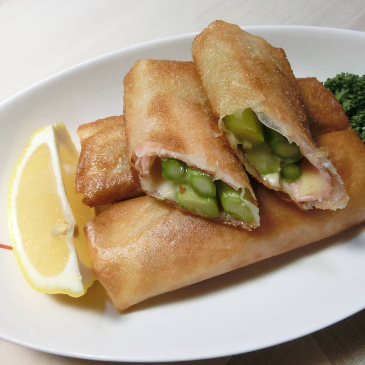 食の都庄内 アスパラガスのチーズ春巻き 材料 5本分 春巻きの皮5枚 アスパラガス10本 ピザ用チーズ サラダ油 作り方 アスパラは半分に切る 根元が硬いものはピーラーで皮をむく 春巻きの皮にアスパラ2本分とチーズをのせて巻く