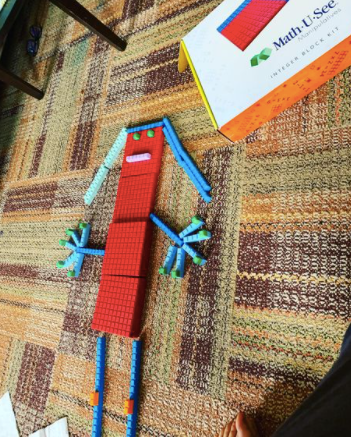 MathsAustralia's tweet photo. Here's a simple game. Ask your child to make a standing man with the blocks, then add up the total number of the whole man. There you go - easy and fun maths that you can do at home with the blocks, teaching basic and multi-digit addition! https://t.co/O9ailPp2XY