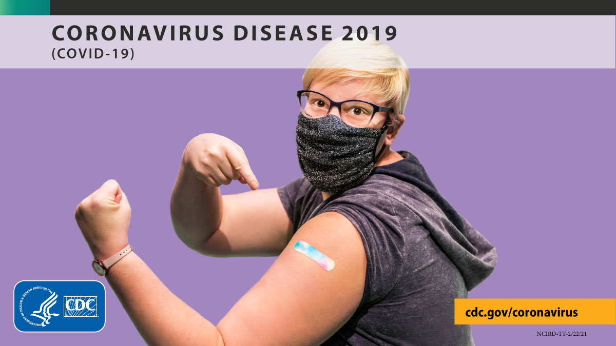 Photo of blond person who is flexing and showing off her bandaid from the vaccine shot. Lavendar background. 