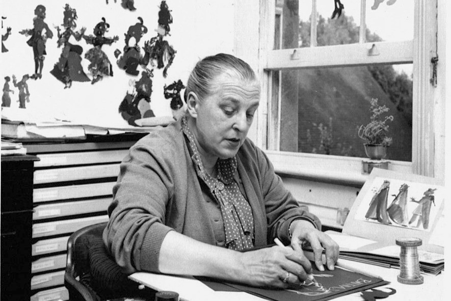 Lotte Reiniger sitting at her desk creating paper cut silhouettes
