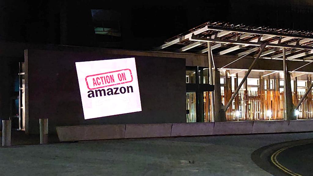 ActionOnAmScot's tweet photo. We’ve shone a light on Holyrood to highlight the working conditions of workers in Amazon. It is not illegal to speak to trade unions in the UK. We need a new deal for Amazon workers! #actiononamazon RT https://t.co/Ke1aWN9ngN