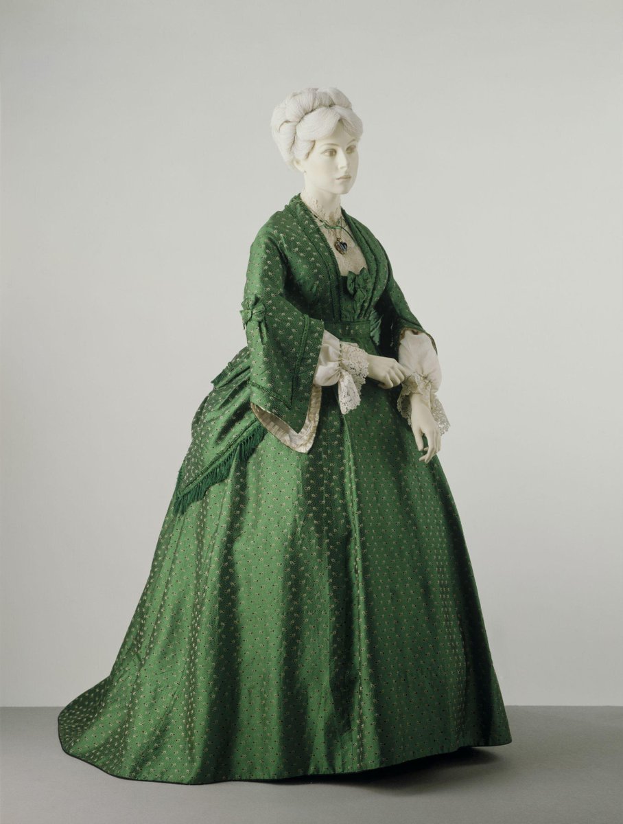 27 - Now for a few gowns with STRUCTURE. This 1872 piece still echoes the big crinolines, but you can see the bustle shifting up and back for easier movement around, you know, one's own life?Could definitely be poison green.