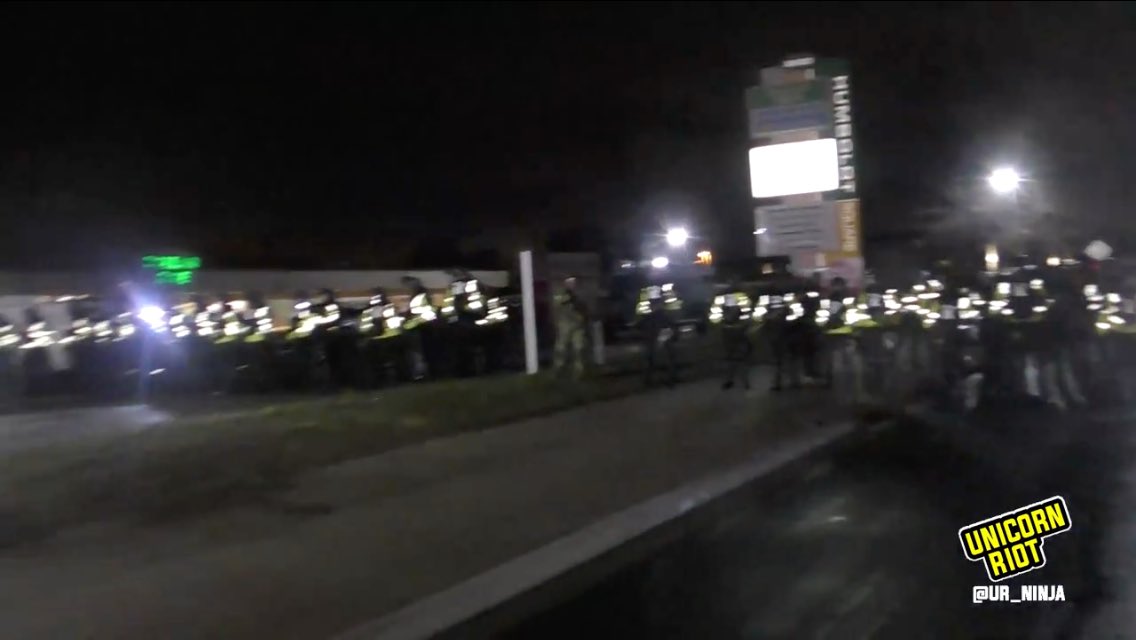 The advancing riot police line has pushed people into this strip mall shopping area