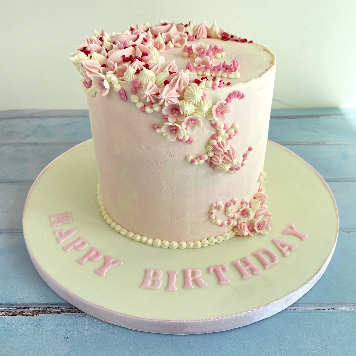 Vanilla and raspberry watercolour buttercream cake with ‘cherry blossom’ and buttercream decoration finished with freeze dried raspberry pieces.
