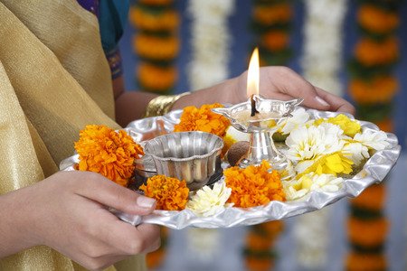 Aarti plate is usually of silver,bronze or copper.A lamp made of kneaded flour, mud or metal is filled with oil or ghee. Cotton wicks must be placed in the lamp and lighted. The plate must also contain flowers,incense and akshat(rice).