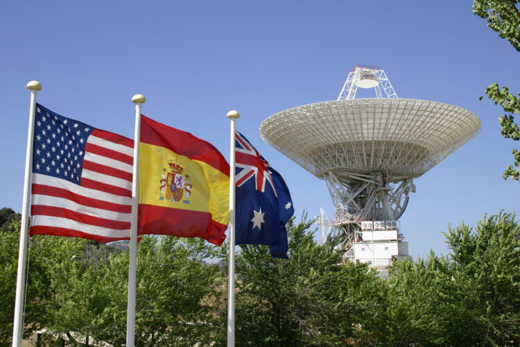 Image of Deep Space Network antenna with American, Spanish and Australian flags (representing the three locations of the Deep Space Network stations), taken at the Madrid complex.