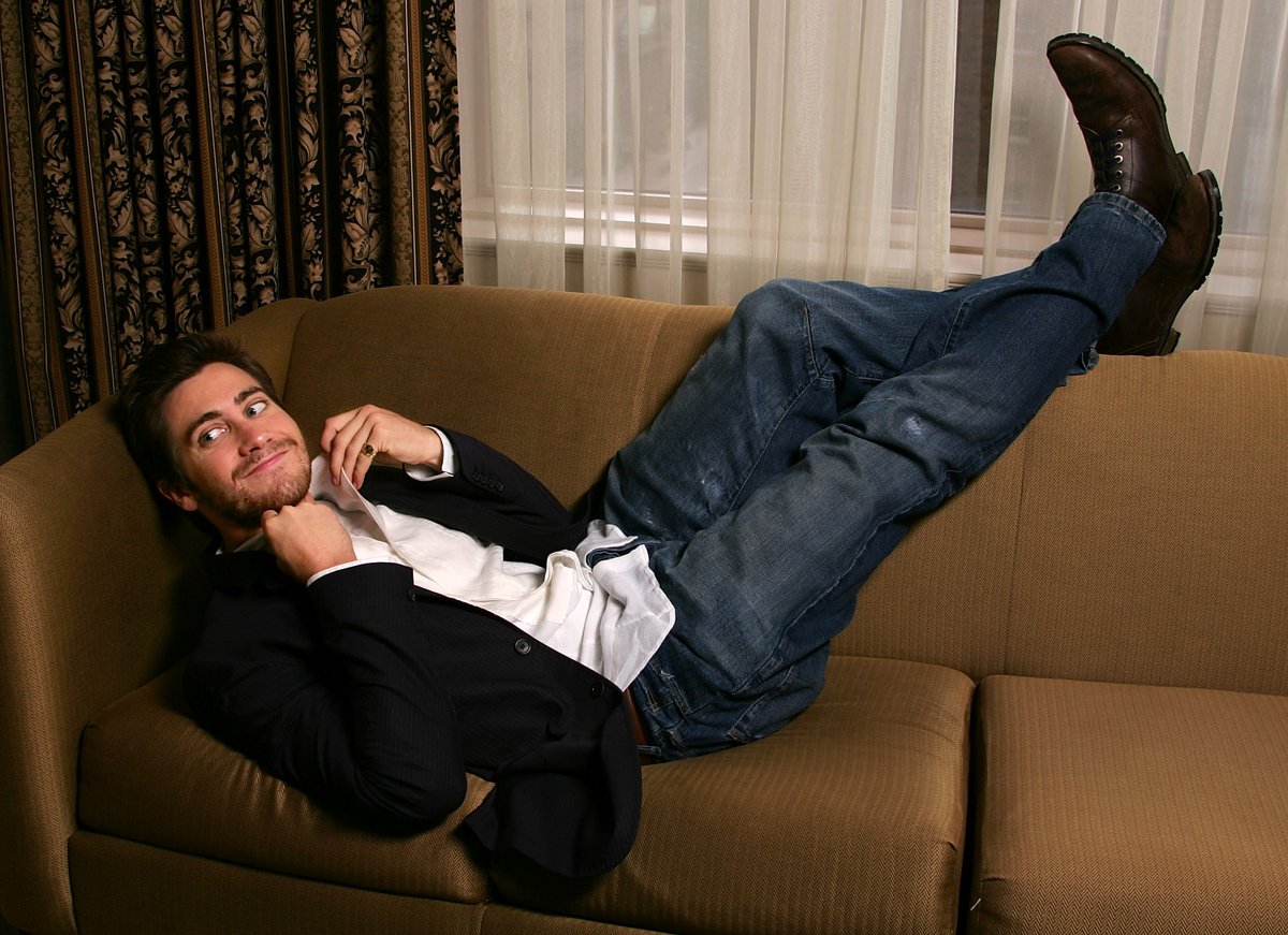 Мужчина лежит нога на ногу. Мужская фотосессия на диване. Парень на диване. Человек на диване. Мужчина лежит.