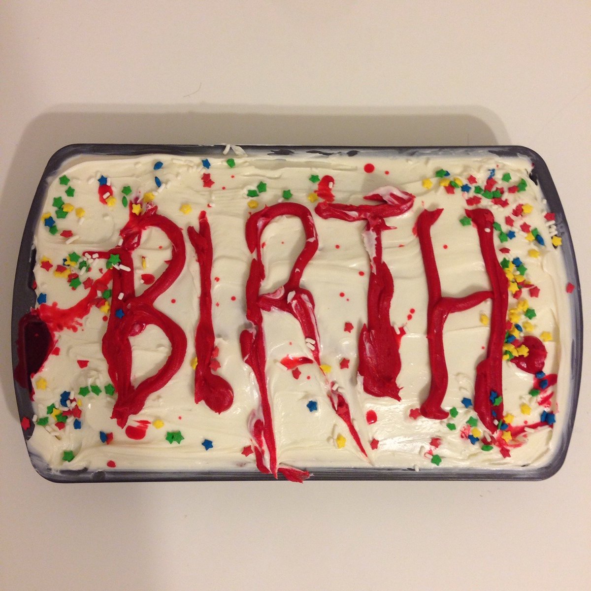 a very ominous cake with the word "BIRTH" written in red frosting...