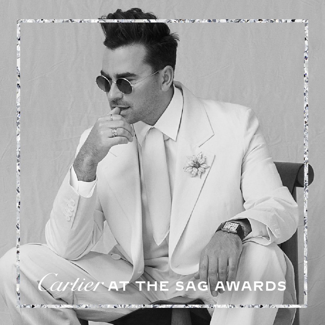 Cartier's tweet photo. Celebrating #SAGAwards 2021 winner @danjlevy in a vintage Cartier brooch, #CartierTank Solo watch, #SantosdeCartier bracelet, Cartier 1895 band and a #TrinitydeCartier ring and band. #CartierRedCarpet at home https://t.co/ijPsFmu84Q
