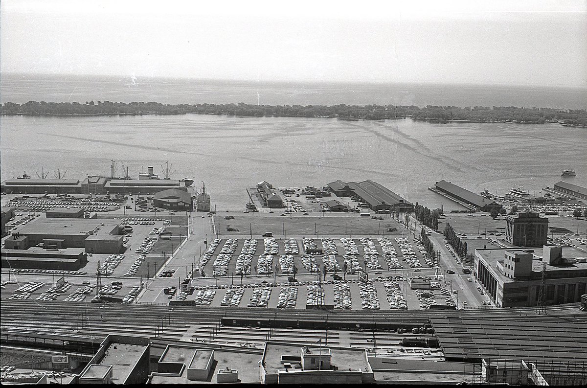  #TPBscan #4The view swings south.1959. No Gardiner. Lots of parking. Marine Terminal 27, with several ships docked (Now Pier 27 condos). Toronto Postal Delivery Building (now Scotiabank Arena). Toronto Harbour Commission Building. Old ferry docks, and a ferry in the water.