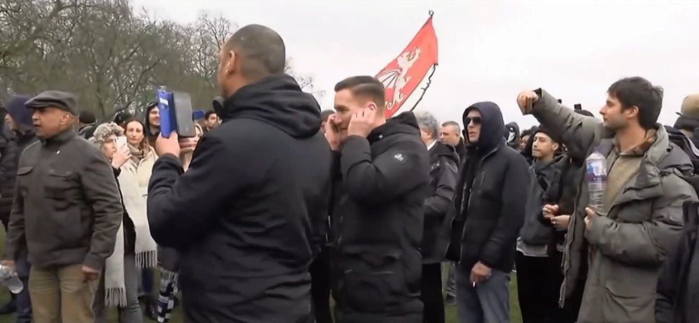 Notice how Heiko shares the megaphone with the Stand up x guy while standing under the far right white Pendragon flag.