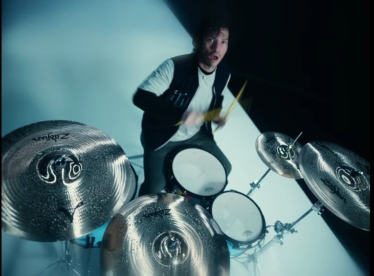 Josh playing drums his mouth open on Shy Away’s music video- A little thread