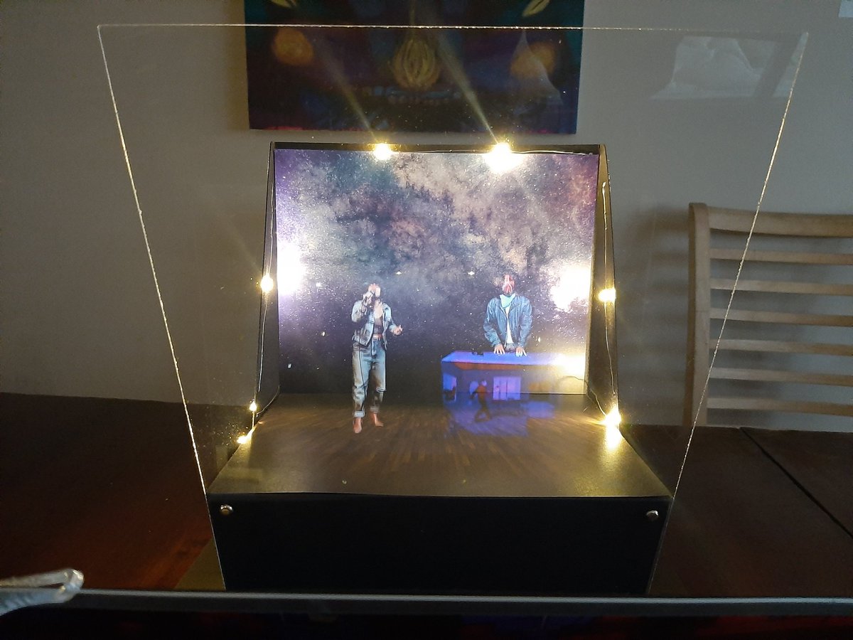 Checking out @womenfromspace hologram festival from the safety of our home in lockdown mode. This cool angled glass projector stage came in the mail when we bought our ticket!