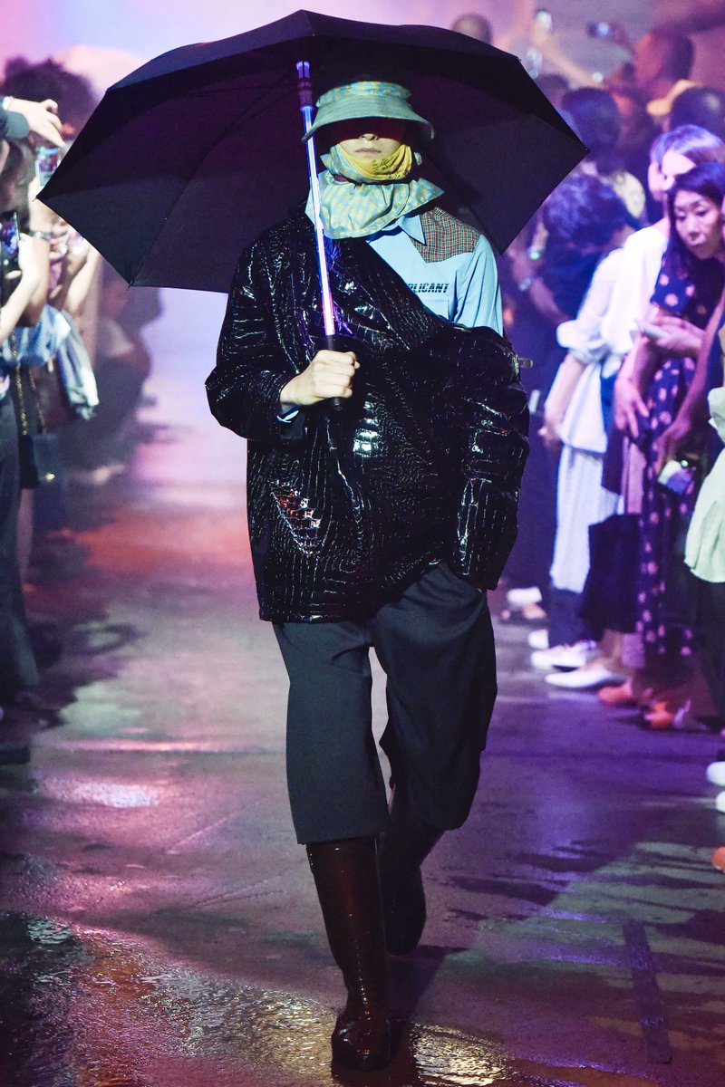For his SS 2018 menswear collection, Raf Simons was inspired by the cyberpunk world of the 1982 film. Draped in oversized silhouettes, both male & female models strode through a futuristic Chinatown setting, hats and umbrellas obscuring their faces and identities from the camera.
