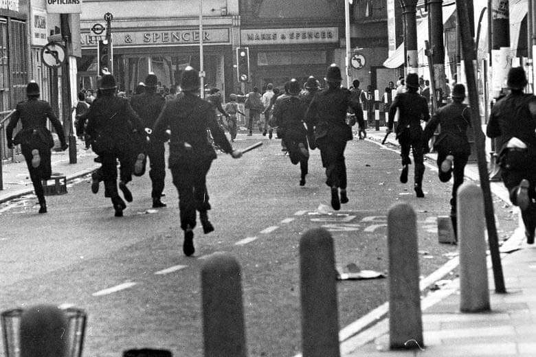 Over 1000 extra police carried out SUS/Swamp 81. In riots, racist 'whites only' pub was targeted. Many arrests. Brixton Defence Campaign defended many arrested. Scarman report, though sympathetic to some locals anger, went down badly, in area. Riots broke out later in year, in UK