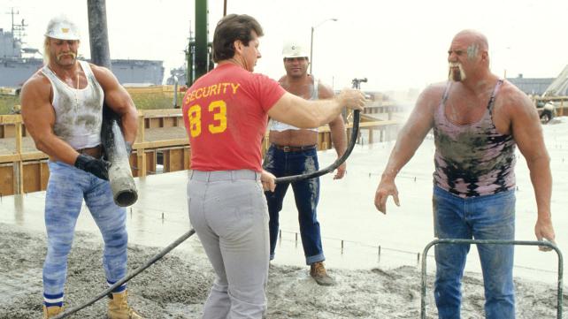 Vince squirting down Superstar Billy Graham, Magnificent Muraco, and Hulk Hogan with a hose.