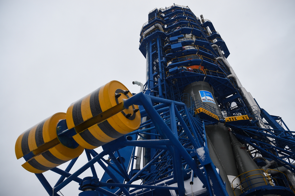 At liftoff, the thrust of the engines will become stronger than the weight of the launcher, and will make Soyuz rise in the air.This will push the 4 arms of the launch pad which will fall by simple gravity thanks to counterweights (the big yellow things you see here)