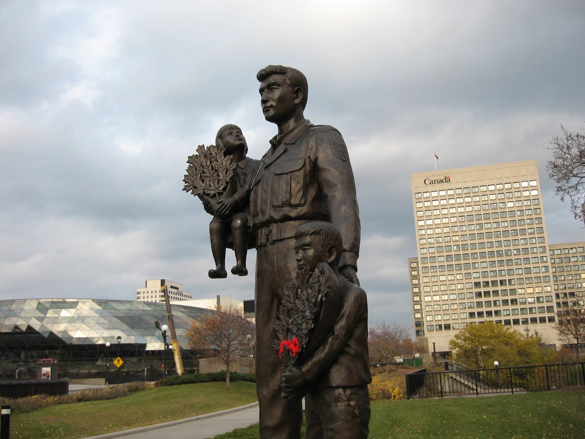 A girl, a boy, and a soldier.They stand in Ottawa facing Korea.Why?