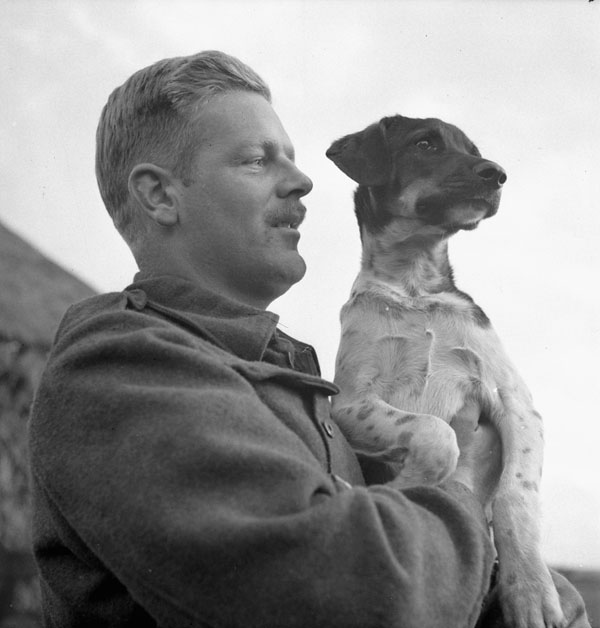 Gunner G.D. Bracken, 4th Field Regiment, Royal Canadian Artillery (R.C.A.), holding Skippy, the unit's mascot, Ossendrecht, Netherlands, 23 October 1944 

amzn.to/3noGnSD