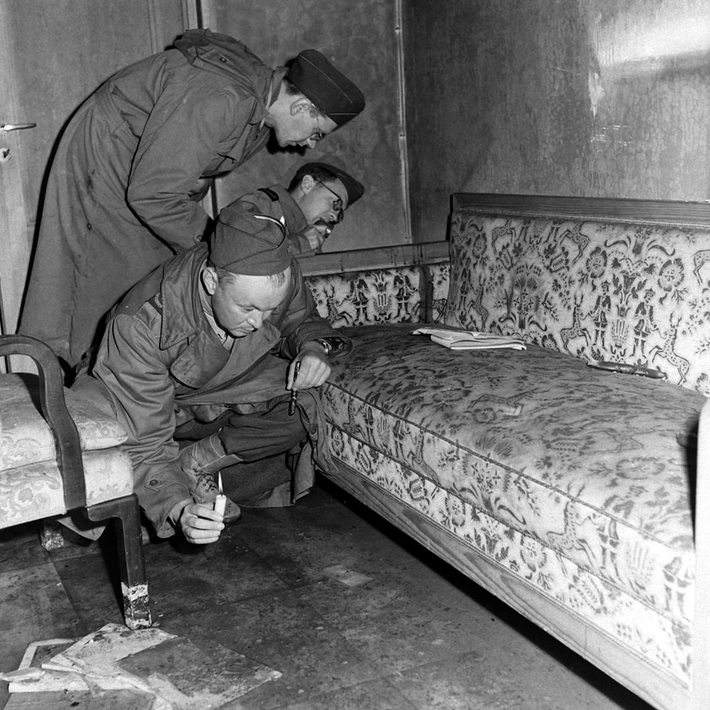 Allied war correspondents examine blood-stained sofa and rug in Hitler’s bunker after suicide of Hitler and Eva Braun, Berlin, this week 1945:      #Vandivert