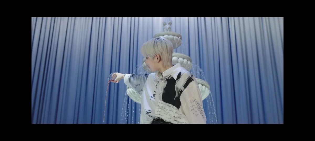 In the MV we see 2 important and sus characters, which are: The white dress girl and Sunwoo.In my mind, the girl is Selene and Sunwoo is Ambrogio. Both take off some blood from themselfs and Sunwoo unites these 2 bloods to pour them on the fountain, so everyone could drink it