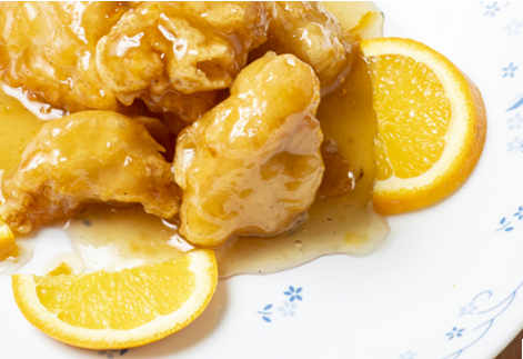Orange-glazed chicken pieces with orange slices
