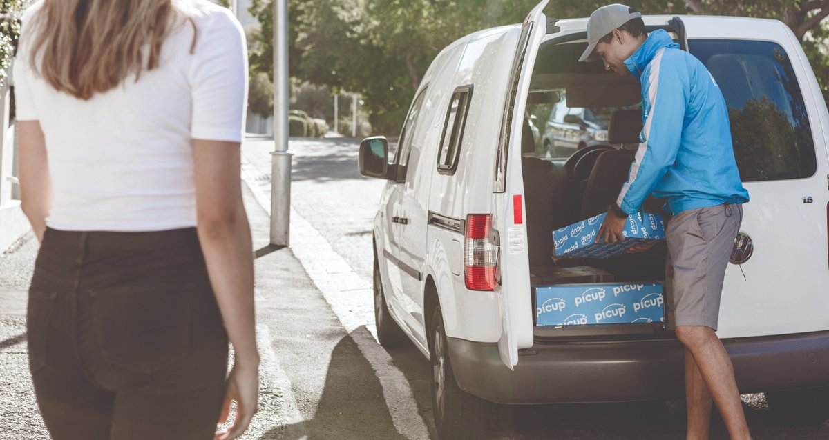 A Picup driver who just arrived at destination searching for the right parcel to deliver to the customer