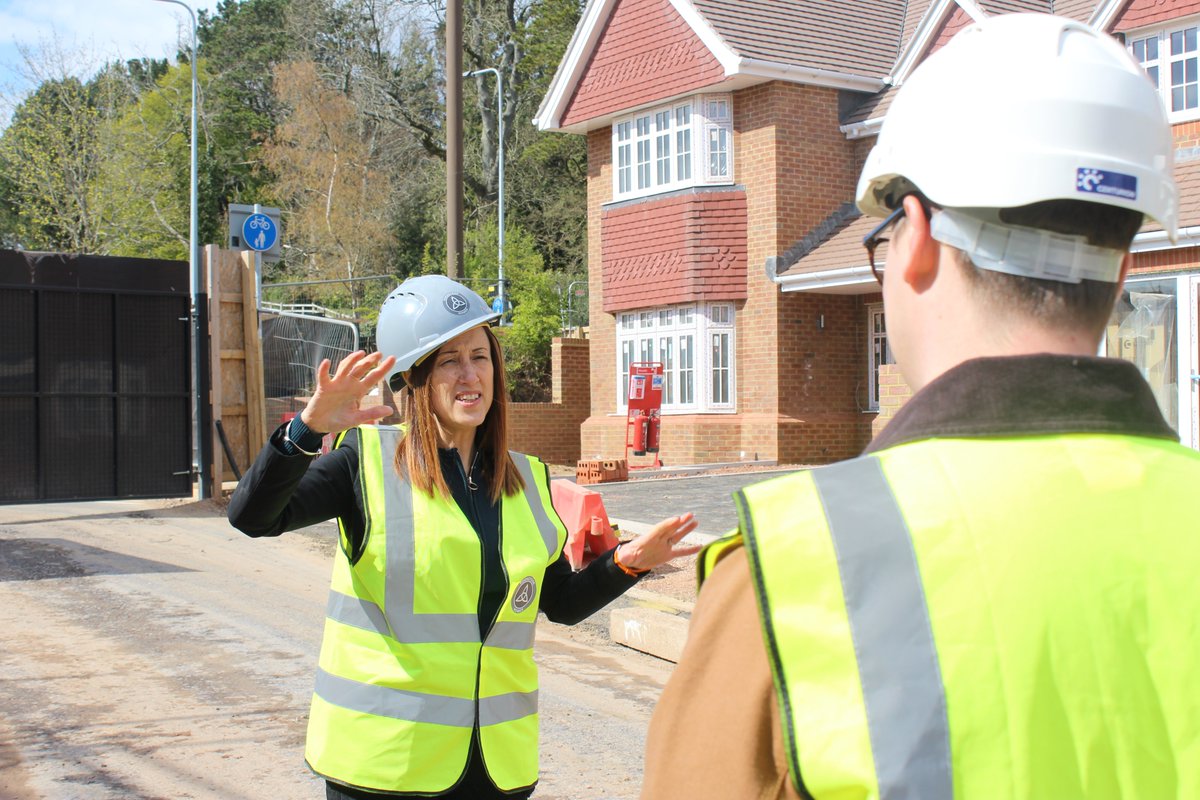 Jane Dodds talking to someone in front of a newly built house.