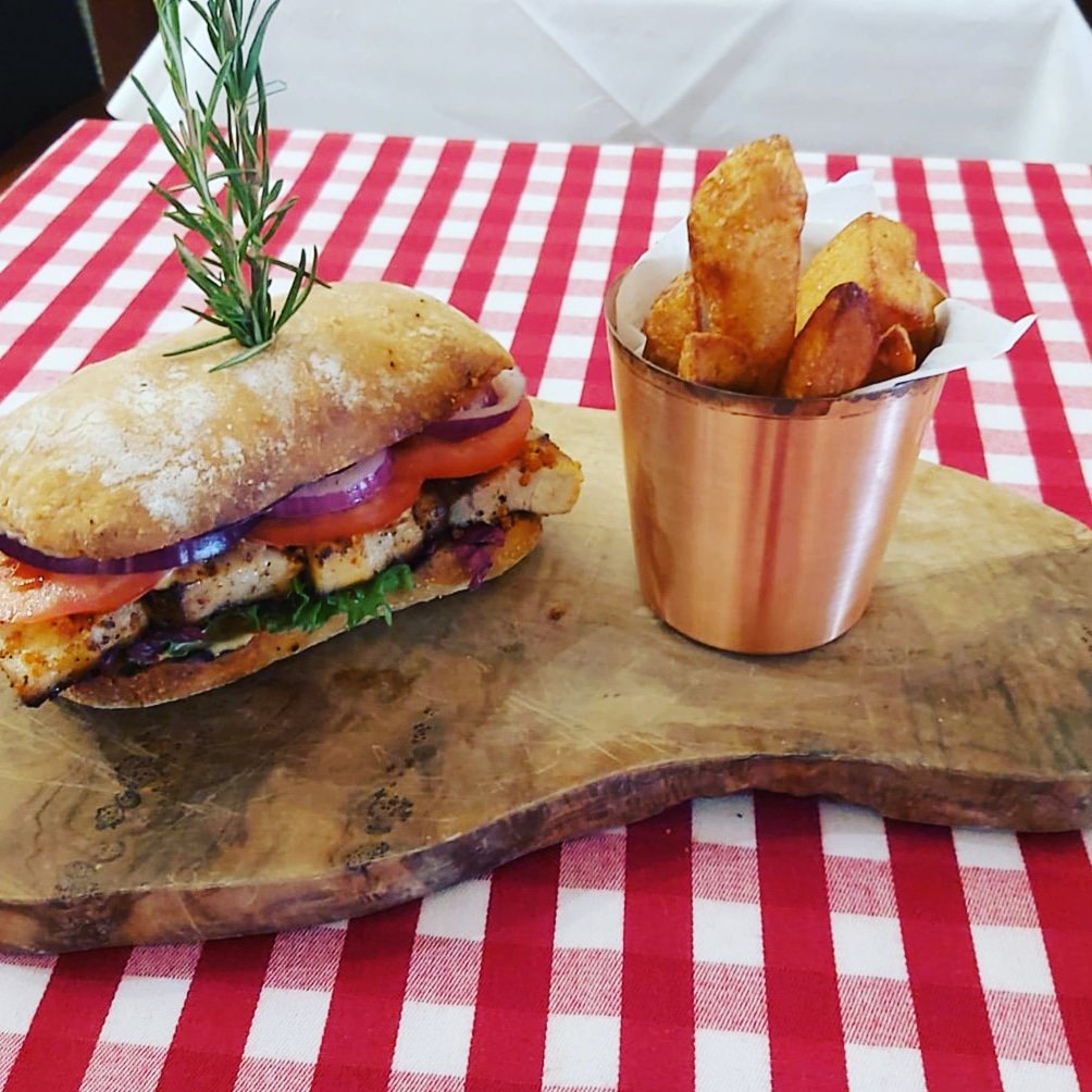 Homesmoked pork belly in sourdough panino with pickled red cabbage,  red onion and rocket, served with homemade chunky chips. Available for takeaway and terrace dining today from 3pm!
