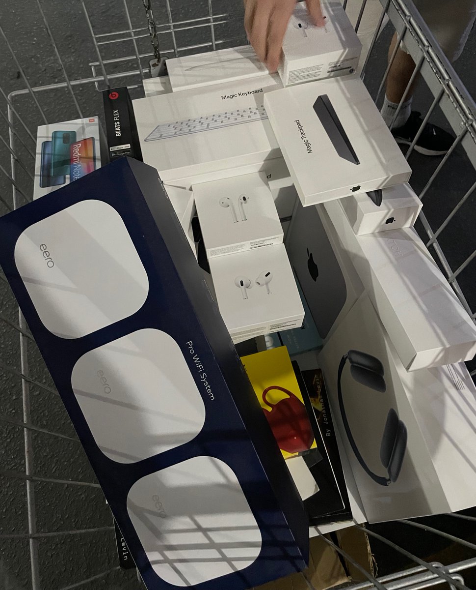 A cart is seen from above full of boxes of Apple products, including several boxes of AirPods