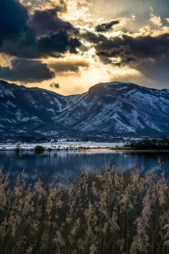 Earth___Beauty's tweet photo. Looking over to Croatia from Bosnia. Last sunrays hitting the snow covered Dinaric Alps. Lipsko Lake near the town of Livno, Bosnia and Herzegovina. [1333x2000] [OC] #earth #nature https://t.co/AXDdzMndR5