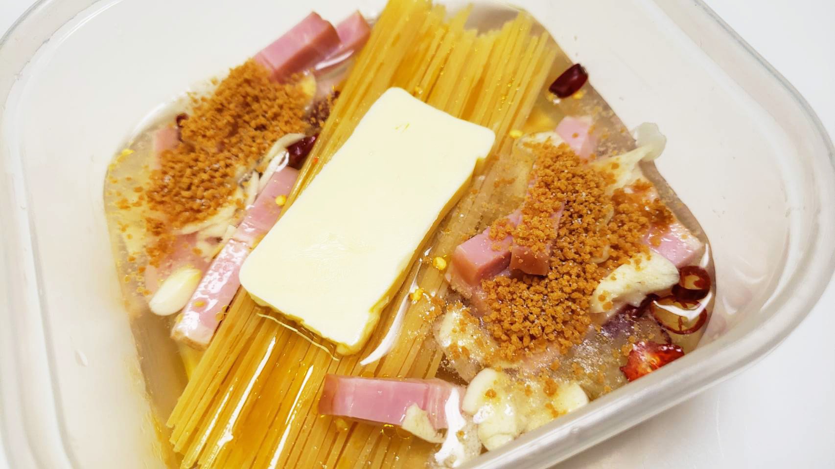 リュウジ 料理のおにいさんバズレシピ レンジで専門店の旨さ チリトマトカルボナーラ 耐熱容器にパスタを半分に折って入れ タマネギ ニンニク ベーコン 鷹の爪と調味料入れ8分チン 生クリーム 粉チーズ タバスコ加えて3分チンし卵黄と黒胡椒