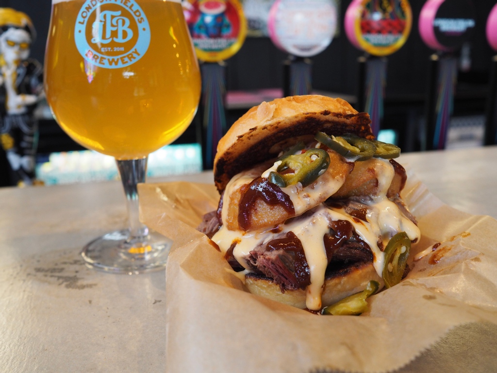 Slow smoked brisket, molten beer cheese sauce, onion ring, pickled jalapeños, all piled high with our award-winning BBQ sauce - meet The Cowtown.
