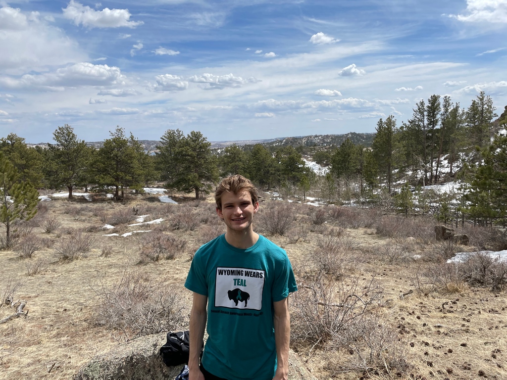 WCADVSA's tweet image. Hugh Ford, AmeriCorps VISTA with Habitat for Humanity of Laramie County, wears teal in support of Sexual Assault Awareness Month on a hike at Curt Gowdy State Park. #WyoWearsTeal #WyomingWearsTeal2021 #SAAM2021
