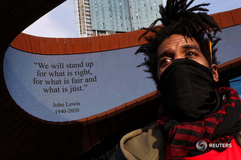 A man looks on underneath a quote from the late civil rights leader John Lewis at the Barclays Center in Brooklyn, New York City, after the verdict. More images from across America:  https://reut.rs/3dwMNf8   Jeenah Moon