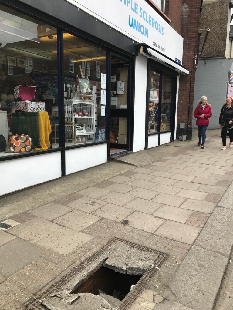 A dangerous manhole outside a shop on East Barnet village! Reported to @BarnetCouncil twice but no one has been! This is directly in front of a shop and on a busy pavement at the heart of #Eastbarnetvillage